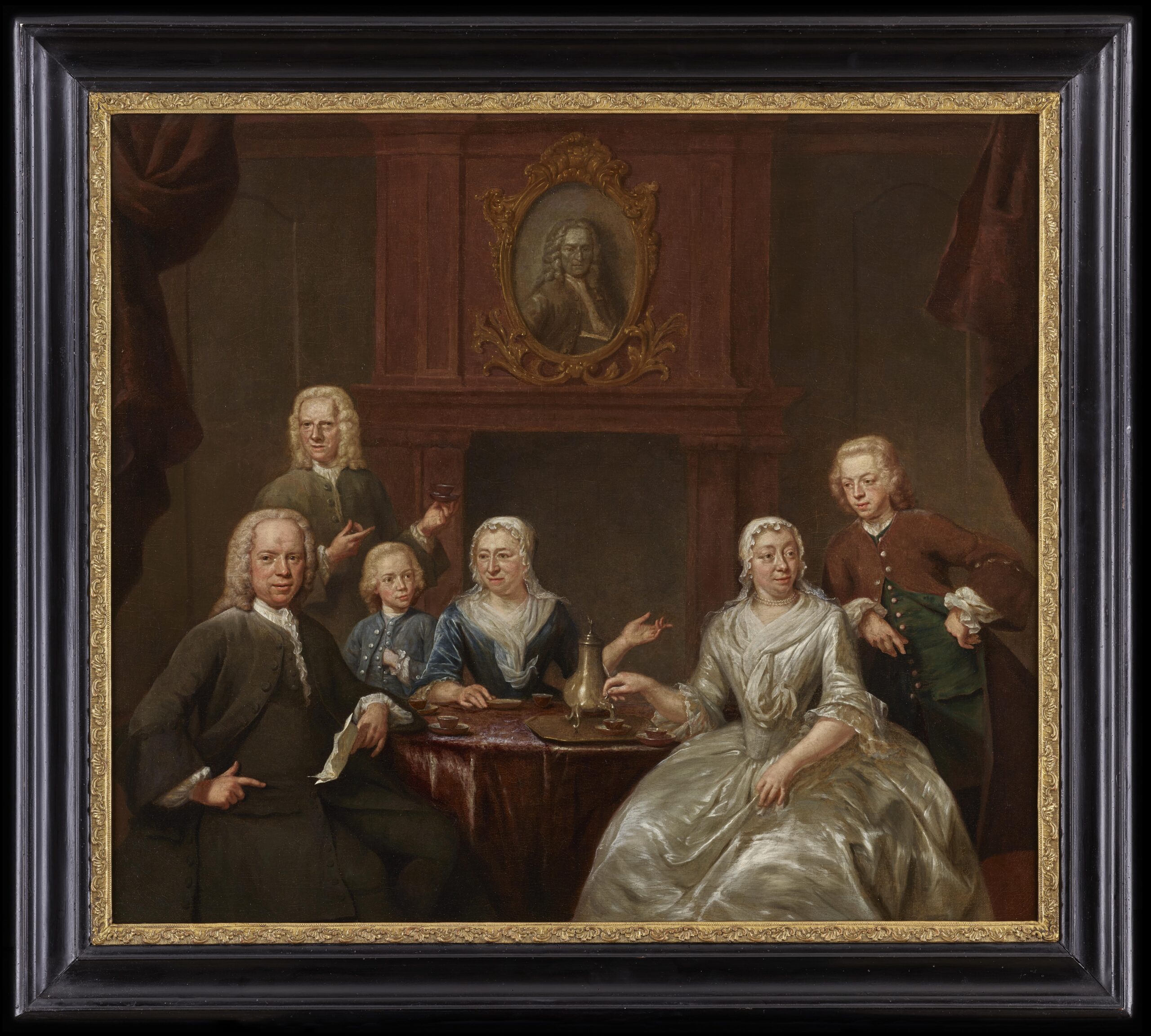 Jan Maurits Quinkhard, A Conversation Piece with a Family seated at a Table with a Coffee Service, a Portrait of a Gentleman over the Mantelpiece - Rafael Valls